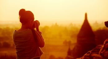 female traveller photographing temples at Bagan Myanmar Asia at sunrise